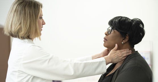 Katherine Hahn, MD, examining a patient's neck
