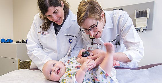 Pediatric dermatologists Dr. Adena Rosenblatt and Dr. Sarah Stein examine a giggling baby